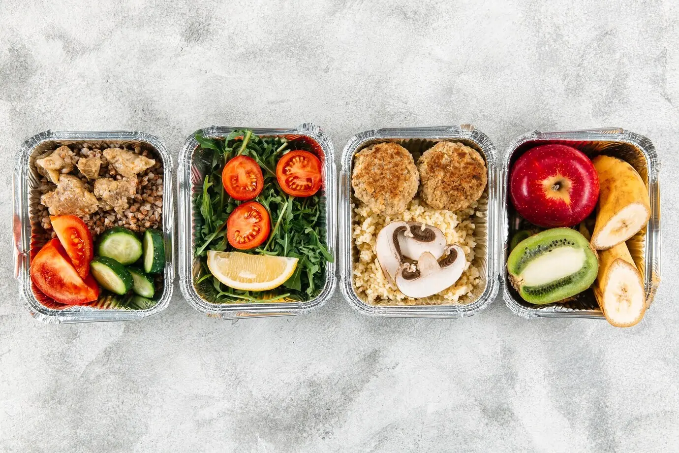 Ansicht von oben auf Gerichte in Auflaufformen mit Obst und Gemüse